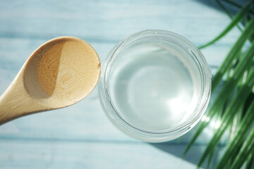 slice of fresh coconut and bottle of oil on a table 