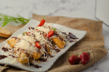 A plate of food with chocolate sauce and strawberries on top