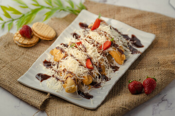 A plate of food with chocolate sauce and strawberries on top