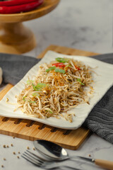 A plate of food with a spoon on a wooden tray