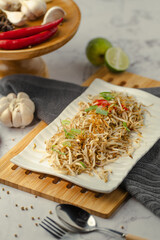 A plate of food with a spoon on a wooden tray