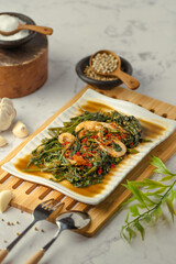 A plate of food with a spoon on a wooden tray
