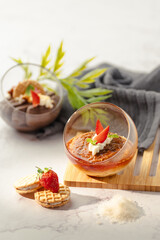 A dessert with strawberries and whipped cream in a glass bowl