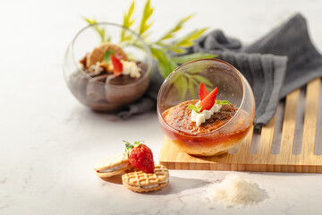 A dessert with strawberries and whipped cream in a glass bowl
