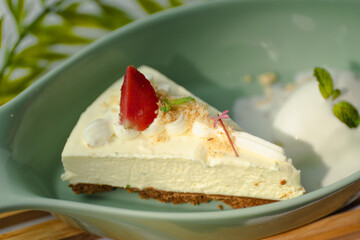A slice of cheesecake with a strawberry on top