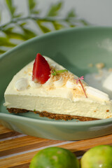 A slice of cheesecake with a strawberry on top