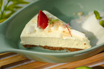 A slice of cheesecake with a strawberry on top
