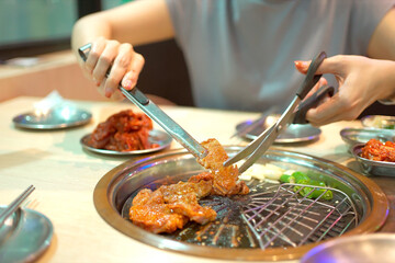 Asian woman eating Korean BBQ.