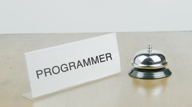 Programmer Office or Room with Hand Ringing The Bell on Desk or Table Multiple Times