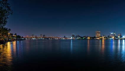 Obraz premium Night Lights Cityscape over Calm Waters