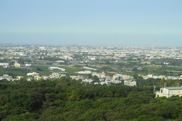 Fototapeta premium A breathtaking view of the countryside from atop a hill, with rolling fields, scattered farms, and winding roads stretching into the distance beneath open skies and natural light. 