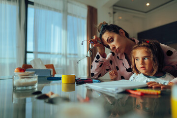 Tired Mother Doing Home Activities with her Little Daughter. Mom lacks energy because she engages...