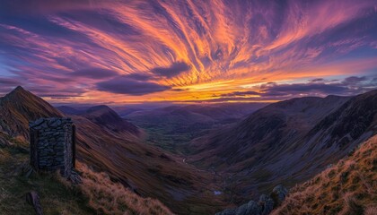 panoramic view from a mountain peak, featuring a clear blue sky dotted with wispy clouds, and a breathtaking vista of valleys and distant hills