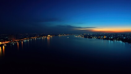 Night Cityscape: Illuminated River and Skyline at Sunset