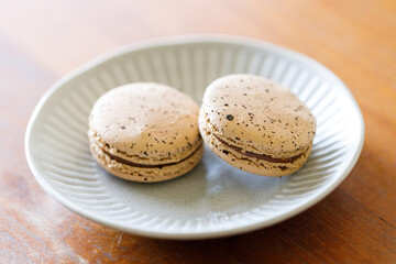 Brown orange Ceylon black tea flavor macaron on wooden table.