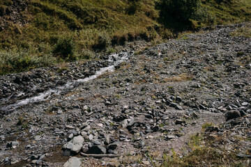 Mountain landscape, mountainous area, green mountains, road in the mountains, river in the mountains. The North Caucasus in all its glory. A dried-up riverbed