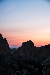 Obraz premium Silhouetted rock formations at sunset in Smith Rock State Park, Oregon.