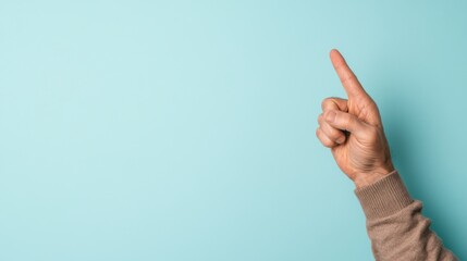 Hand gesturing upwards against a light blue background.