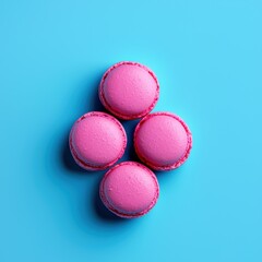 Obraz premium Four Pink Macarons on a Blue Background