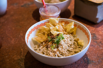  Indonesian sweet-savory noodles topped with seasoned minced chicken, crispy wontons crackers, and green onions. Served dry with separate broth. this is Mie Yamin asin