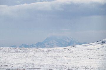 Fog over top of sowy mountain on a cold spring day on the Denali Highway in Alaska. © Kari