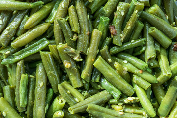 A close up of green beans with a sprinkle of seasoning