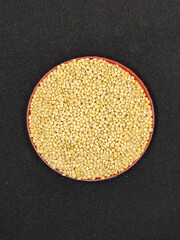 Millet seeds in red container. Millet seeds for bird feed.