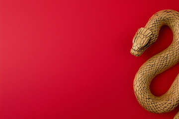 Fototapeta premium Golden snake on a red background, Chinese New Year concept