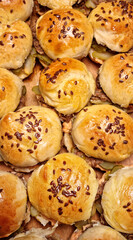 Top-down view of sliders filled with pulled pork, arranged side by side, with buns sprinkled with flax seeds