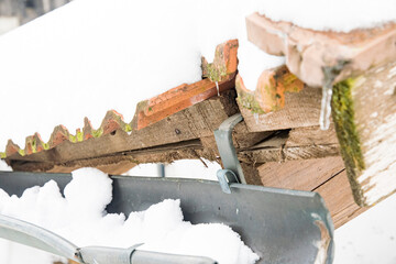 damaged roof with a lot of snow in the winter