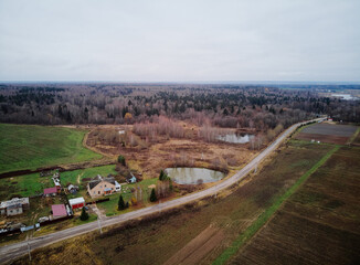 Aerial view of a rural landscape with a road, fields, houses, and small ponds.