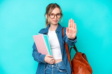 Young student woman isolated on blue background making stop gesture