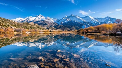 Obraz premium Pristine Mountain Reflection: Snow-Capped Peaks and Serene Lake
