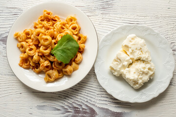 Tortellini with tomato sauce on a white plate