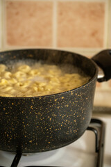 Raw Italian tortellini black pan in close-up
