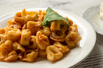 Tortellini with tomato sauce on a white plate