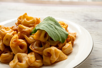 Tortellini with tomato sauce on a white plate