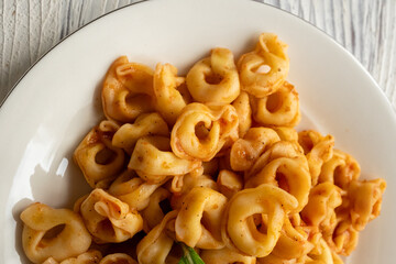 Tortellini with tomato sauce on a white plate