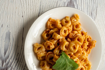 Tortellini with tomato sauce on a white plate