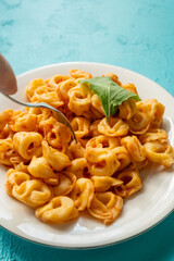 Tortellini with tomato sauce on a white plate