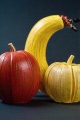 Colorful sculpted vegetables: a red pumpkin, yellow pumpkin, and a quirky banana.