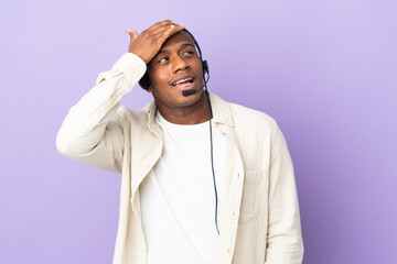 Telemarketer latin man working with a headset isolated on purple background smiling a lot