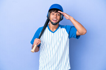 Baseball caucasian man player with helmet and bat isolated on blue background with surprise expression