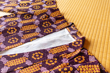 Japanse haori jacket with purple and orange pattern placed on tatami mats.