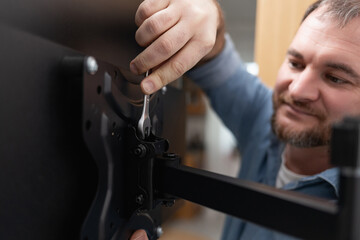 Man hands installing mount TV on the wall