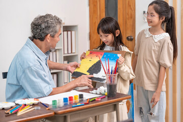 teen girls enjoy drawing watercolors with a senior experienced teacher,elementary students learning new skill of art during school break
