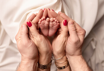 Children's feet in the arms of their parents. On a white background.	
