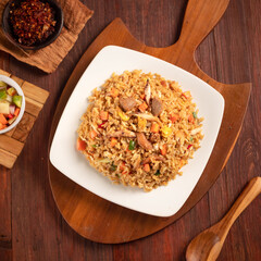 delicious fried rice with vegetables pickles in a wood background
