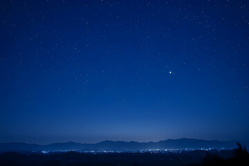 Fototapeta premium Night Sky over Distant City Lights and Mountains