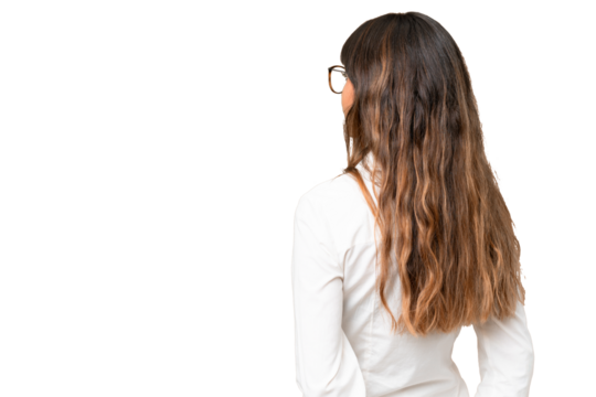 Young caucasian woman over isolated chroma key background in back position and looking back